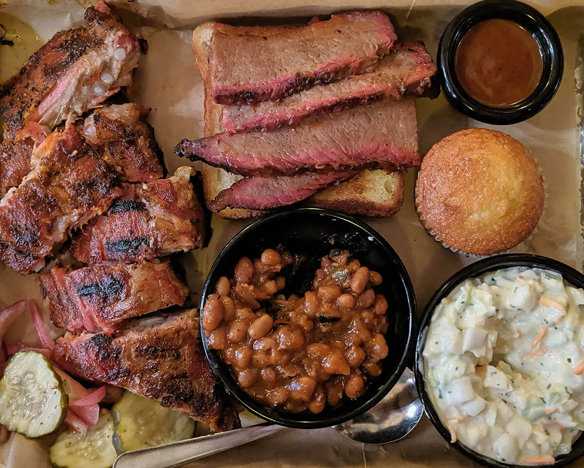BBQ meat with baked beans, coleslaw and cornbread sides