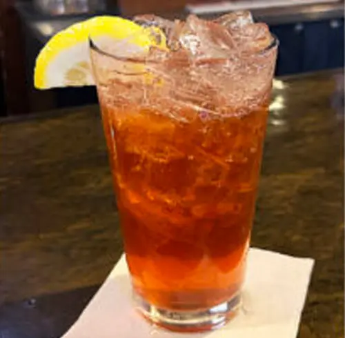 Blackberry Bourbon Lemonade cocktail with a lemon wedge