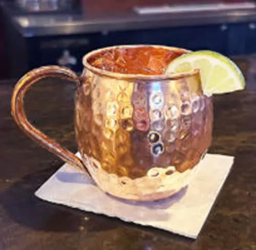Kentucky Mule beverage in a tin cup with a lime wedge 
