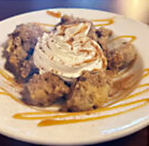 Vanilla Cinnamon Bread Pudding dessert on a plate with caramel drizzle on top 