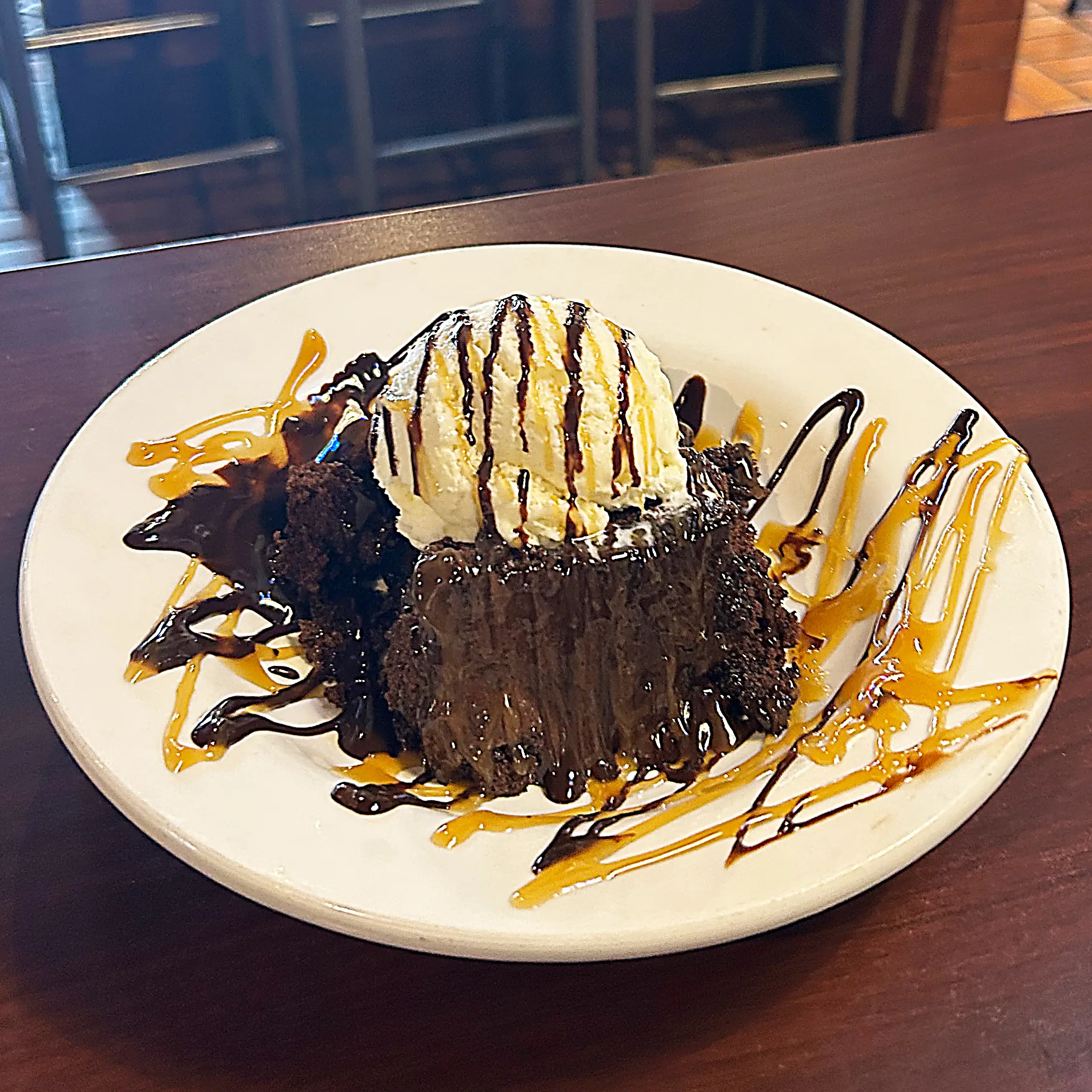 Chocolate Sundae Cake on a plate with ice cream and chocolate drizzle on top 